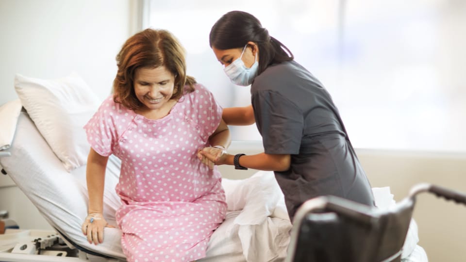 Doctor helps patient stand up