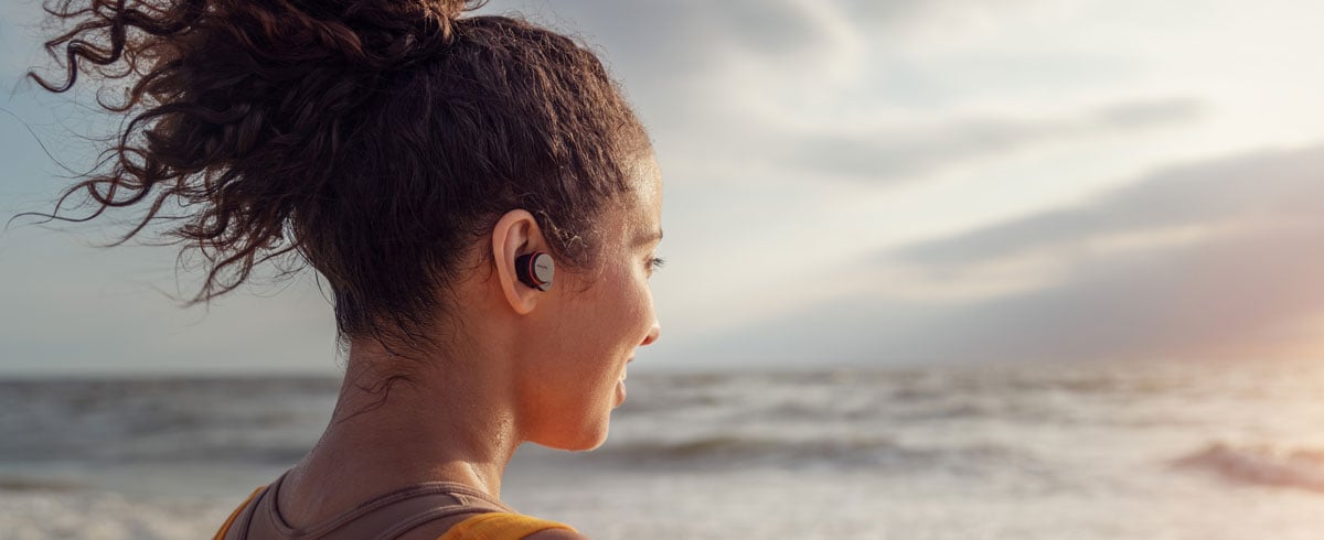 Жени използват истински безжични слушалки на морския бряг