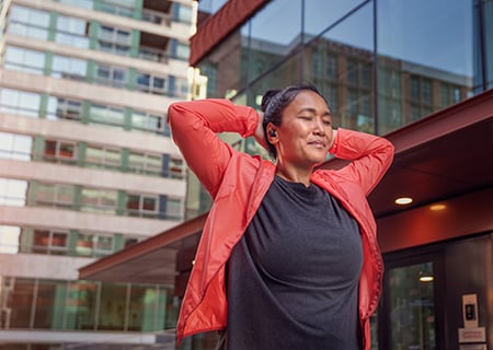 Жена използва безжични слушалки Philips A5508 на открито