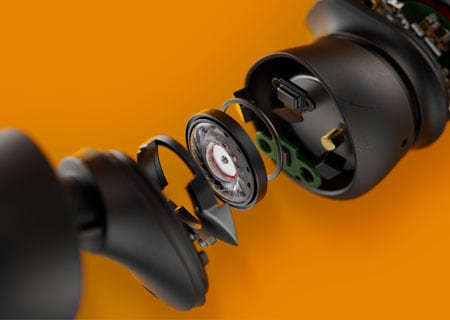 Техническо изображение в близък план, показващо вътрешните части на истински безжични слушалки