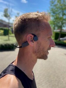 Бягащ мъж със слушалки с костна проводимост